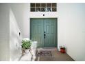 Close-up of the double front doors, showcasing the textured white walls, plants, and decorative door mat at 6035 Falconbridge Pl, Mount Dora, FL 32757