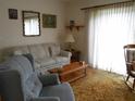 Cozy living room with floral sofa set, rocking chair, natural light, and plush carpet at 713 Lillian Cir, Eustis, FL 32726