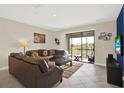 Relaxing living room with tile flooring, sliding glass doors to patio, and comfortable seating at 9040 Azalea Sands Ln, Davenport, FL 33896