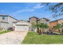 Inviting single-Gathering home with a brick driveway, stone accents, and a practical two-car garage at 9188 Chandler Dr, Groveland, FL 34736