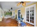 Inviting front porch with comfortable seating, ceiling fans, and wood floors at 932 N Mcdonald St, Mount Dora, FL 32757