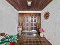 Elegant foyer showcasing double doors, tile flooring, and a decorative sunburst wall art at 9829 Wedgewood Ln, Leesburg, FL 34788