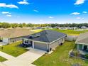 Exterior view of a gray home with a well-maintained lawn and attached garage at 10420 E 161St St, Summerfield, FL 34491