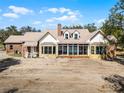 Spacious home exterior featuring a sunroom and brick accents at 10944 Autumn Ln, Clermont, FL 34711