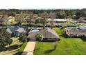 Aerial view of a single story brick home with an attached garage, and lawn at 12320 Blue Heron Way, Leesburg, FL 34788