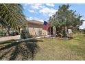 Well-manicured lawn with decorative touches, featuring a flagpole and landscaping at 12497 Se 92Nd Ave, Summerfield, FL 34491