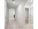 Bright hallway featuring neutral tile flooring, arched doorways, and crisp white trim at 125 Sunny Day Way, Davenport, FL 33897