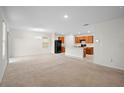 Inviting living room and kitchen combination featuring neutral walls, carpeted floors, and a chandelier at 125 Sunny Day Way, Davenport, FL 33897