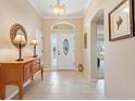 Welcoming entryway with decorative glass door and transom window, leading to a bright and open interior at 1357 Owl Dr, The Villages, FL 32163