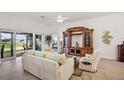 Bright living room with a neutral palette, tile flooring, a ceiling fan and sliding glass doors to the patio at 1603 Mcmurtrie Loop, The Villages, FL 34762