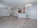 Spacious living room features modern lighting and hardwood floors, flowing to the kitchen at 1671 Campos Dr, The Villages, FL 32162