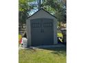 View of a storage shed with a gray exterior, double doors, and a peaked roof at 18316 Keene Rd, Altoona, FL 32702