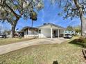 Welcoming single-story home with a carport and porch, providing a comfortable and accessible living space at 206 Aspen Cir, Leesburg, FL 34748