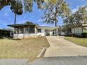 Inviting single-story home with a convenient carport and a screened-in porch, nestled in a tranquil neighborhood at 206 Aspen Cir, Leesburg, FL 34748