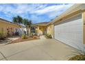 Charming home featuring desert landscaping in front yard, a driveway, and a two-car garage at 2165 Smoaks St, The Villages, FL 32162