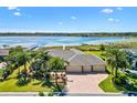 Beautiful waterfront estate featuring a three car garage, large circular driveway, and lush landscaping at 2332 Clearwater Run, The Villages, FL 32162