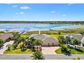 Expansive lakefront home with lush landscaping, brick driveway, and private dock at 2332 Clearwater Run, The Villages, FL 32162