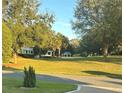 Scenic community park featuring lush green space, mature trees, winding path, and charming gazebos, creating a relaxing atmosphere at 2427 Tamarind Grove Run, The Villages, FL 32162