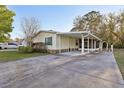 A single-story home featuring a covered carport, landscaped front yard and a paved driveway at 2557 Karen Dr, Mount Dora, FL 32757