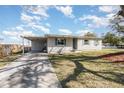 View of a well-kept single-story home, showcasing its carport and driveway with lush lawn and tree at 2803 Joleen Dr, Eustis, FL 32726