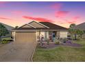 Charming single-story home with a meticulously landscaped yard and inviting blue front door set against a vibrant sky at 3330 Mayflower Loop, The Villages, FL 32163