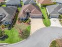 An aerial view of a well-maintained home, showcasing its landscaping, two car garage, and neighborhood at 3540 O'Brien Pl, The Villages, FL 32163