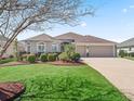 Well-kept home exterior boasting a manicured lawn, lush landscaping, and a convenient two-car garage at 3540 O'Brien Pl, The Villages, FL 32163