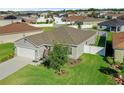 This charming property features an attached two-car garage, a well-kept lawn, and mature landscaping at 3935 Fescue St, Clermont, FL 34714