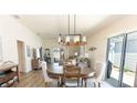 Open dining room with modern lighting, wood floors, and sliding door access to the outside at 4036 Venetian Ln, The Villages, FL 32163