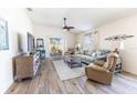 Bright living room with wood floors, ceiling fan, and sliding glass doors to the backyard at 4036 Venetian Ln, The Villages, FL 32163