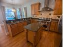 Spacious kitchen featuring granite countertops, stainless steel appliances, and hardwood floors at 42316 E Saffron Ct, Eustis, FL 32736