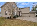 Spacious home featuring a large three-car garage and lush landscaping at 4654 Coppola Dr, Mount Dora, FL 32757