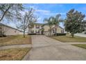 Charming two-story home with a long driveway, lush landscaping, and a welcoming facade at 4654 Coppola Dr, Mount Dora, FL 32757