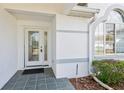 Close-up of the front door featuring a glass panel door and decorative window feature at 5332 Nw 20Th Pl, Ocala, FL 34482