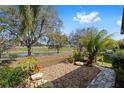 Spacious backyard with lush landscaping and a serene pond view, perfect for outdoor relaxation at 565 Brighton Dr, The Villages, FL 32162