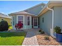 Charming single-story home featuring a brick walkway, meticulous landscaping, and front-facing bay windows at 5718 Illumination Ln, Leesburg, FL 34748