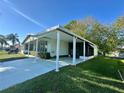 Charming single-story home featuring a spacious carport, inviting driveway, and lush green lawn at 607 Webb Way, The Villages, FL 32159