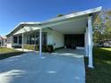 Charming single-story home featuring a spacious carport, inviting driveway, and lush green lawn at 607 Webb Way, The Villages, FL 32159