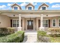 Inviting front porch with stone supports, manicured landscaping, and a welcoming entrance at 6206 Ocilla Loop, Clermont, FL 34714