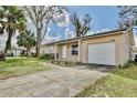 Inviting home featuring well-kept lawn, attached garage and a concrete driveway leading to the entrance at 7036 Clarcona Ocoee Dr, Orlando, FL 32818