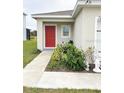 Close-up of the front entrance featuring a bright red door and manicured landscaping at 726 Eagle Landing Blvd, Winter Haven, FL 33880