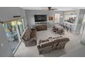 Open-concept living room with cozy seating, a modern TV, and seamless transition to the kitchen area at 906 Calabria Ave, Davenport, FL 33897