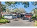 Charming single-story home featuring a lush landscaped yard and a striking red garage door at 925 Northside Dr, Mount Dora, FL 32757