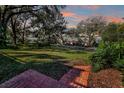 Serene front lawn view with brick steps, mature trees, and neighborhood street at 925 Northside Dr, Mount Dora, FL 32757