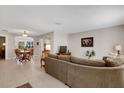 Open-concept living room with neutral walls, tile flooring, and a comfortable large sectional sofa at 9511 Se 168Th Elderberry Pl, The Villages, FL 32162