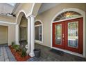 Covered porch featuring a double front door, columns, and arched windows at 1075 Ceasars Ct, Mount Dora, FL 32757