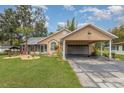 Single-story home featuring a carport and well-maintained front yard with an elegant tropical garden at 11415 Palmetto Dr, Tavares, FL 32778