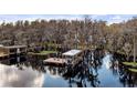 View of the private dock with boat lift and seating area for relaxing on the water at 12117 Cypress Ln, Clermont, FL 34711