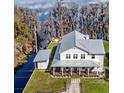 Aerial view showcases a lovely two story home with a spacious lawn with a nearby lake view at 12117 Cypress Ln, Clermont, FL 34711
