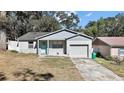 Charming single Gathering home with a garage, colorful door and landscaped yard at 151 Shiloh Ave, Lady Lake, FL 32159